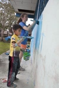 Volunteer tourists painting the school
